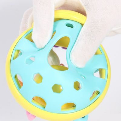 Gros plan sur une balle sensorielle bébé au design ajouré facilitant la préhension, jouet d’éveil adapté aux petites mains