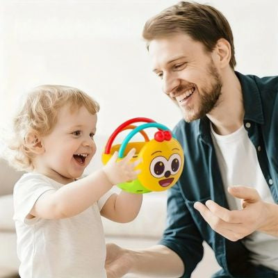 Parent et bébé jouant ensemble avec une balle sensorielle de préhension souriante, jouet d’éveil favorisant l’interaction, la motricité fine et la coordination