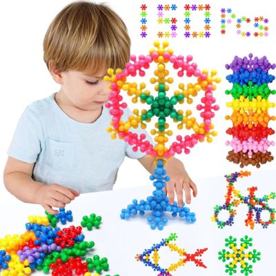 Enfant réalisant des créations géométriques colorées avec des blocs flocon de neige STEM, jeu éducatif développant la logique, la créativité et la concentration
