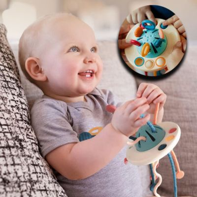 Bébé tenant un jouet sensoriel hibou Montessori avec cordes et formes à manipuler, jouet d’éveil favorisant la préhension et la motricité fine