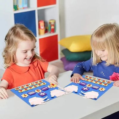 Deux enfants utilisant un tableau mathématique Montessori en feutre pour apprendre les chiffres et les opérations de manière ludique