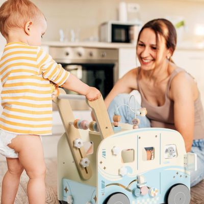 Trotteur en bois TravelBus pour bébé utilisé lors d’un moment de jeu parent-enfant, jouet Montessori favorisant la marche, la motricité et le lien affectif au quotidien
